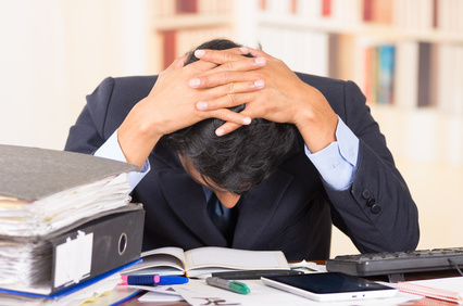 overwhelmed young man with piles of work